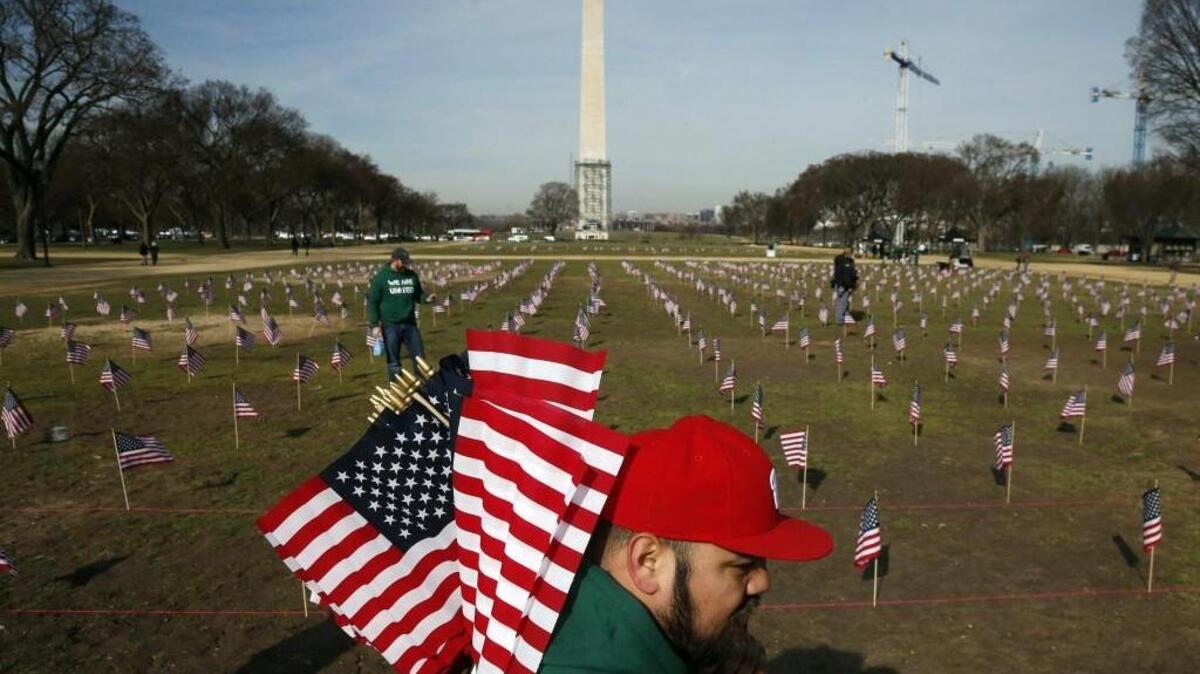 An Army veteran works with others from Iraq and Afghanistan Veterans of America (IAVA) to place 1,892 flags representing veteran and service members who have died by suicide to date in 2014 on the National Mall in Washington, Thursday, March 27, 2014. The event also marked the introduction of The Suicide Prevention for America's Veterans Act by Sen. John Walsh, D-Mont., which calls for greater access to mental health care.