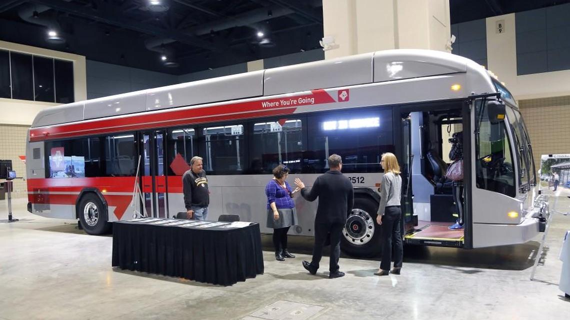 Attendees chat in front of a Gillings rapid transit bus on display at the Raleigh Convention Center last December.