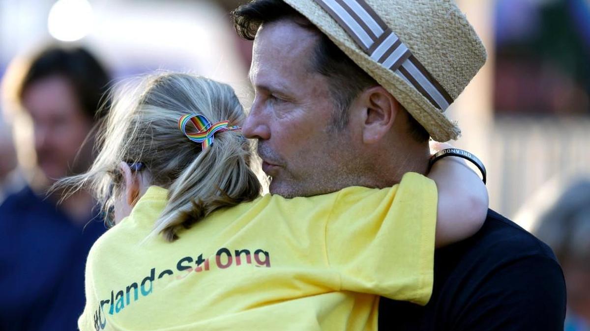 Kira Humphrey, 7, hugs her uncle Patrick James at a street party in Orlando, Fla., to benefit the employees of the Pulse nightclub, the scene of the recent mass shooting.