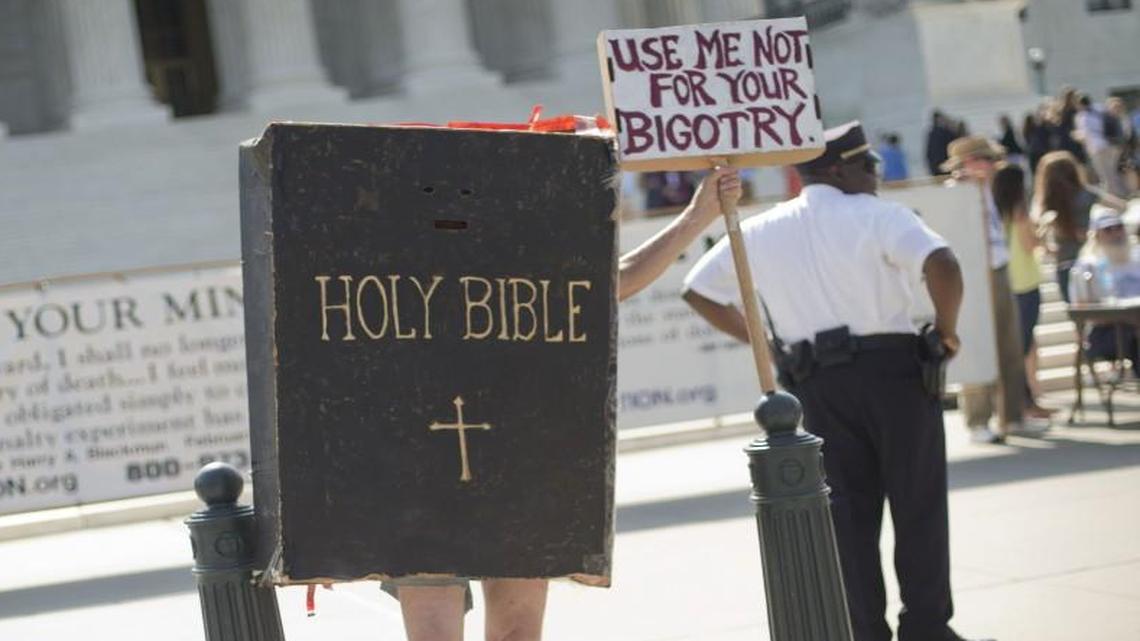 A demonstrator dressed as the Bible stands outside the Supreme Court building awaiting the court’s decision on the Hobby Lobby case in Washington in 2014.
