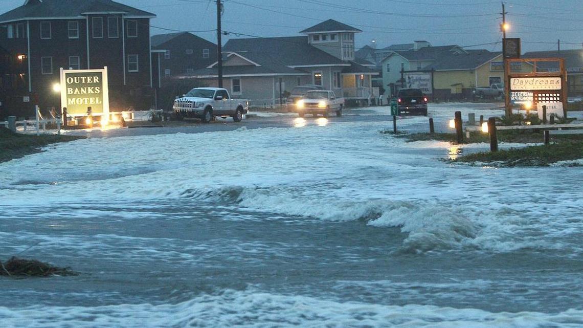 Water from the Atlantic Ocean rolls over N.C. 12 at the north end of Buxton on Hatteras Island in 2012 as Hurricane Sandy waves batter the island.