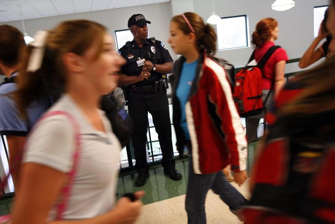 An East Chapel Hill High school resource officer watches students walking in the hallways during a class change in this 2006 file photo.