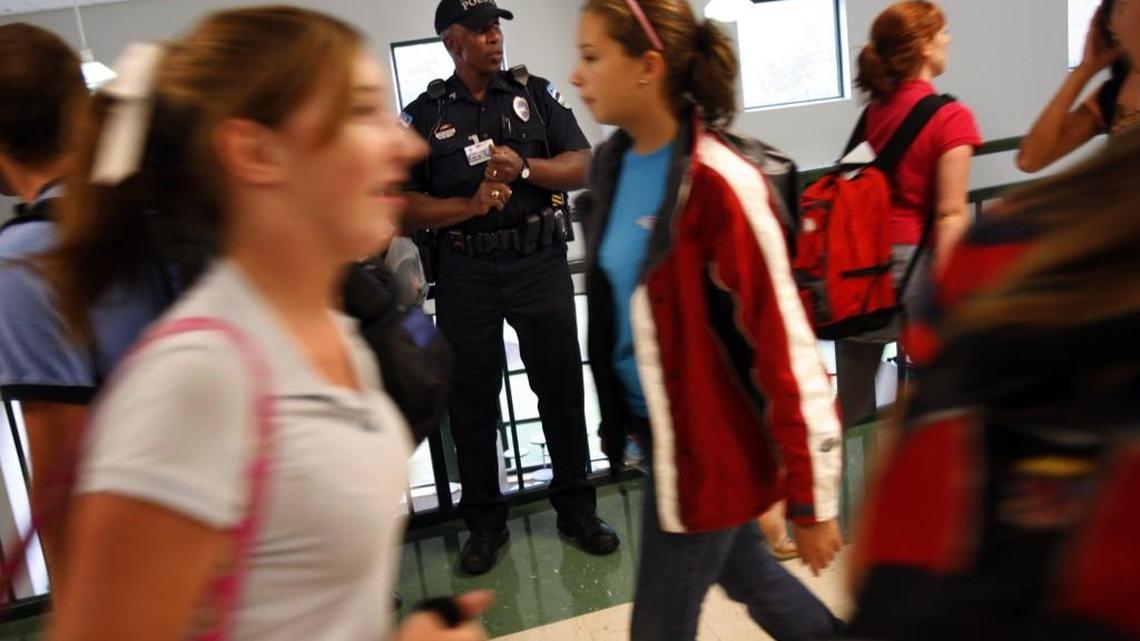 An East Chapel Hill High school resource officer watches students walking in the hallways during a class change in this 2006 file photo.