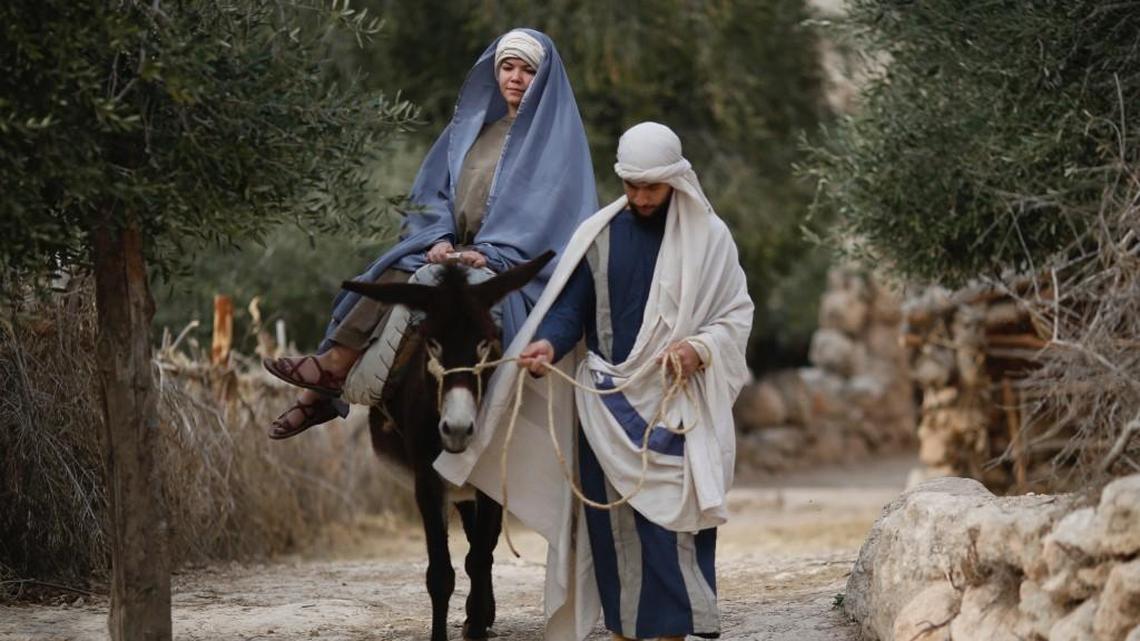 Christian actors portray Joseph and Mary during a re-enactment of a Nativity scene of the journey to Bethlehem as part of Christmas festivities at the Nazareth Village, northern Israel, Thursday, Dec. 21, 2017.