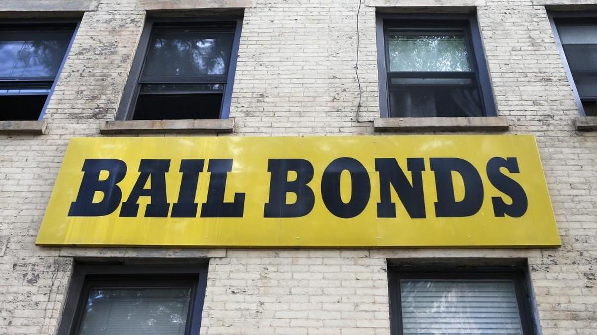 In this photo taken Tuesday, July 7, 2015, a bail bonds sign hangs on the side of a bail bonds business near Brooklyn’s courthouse complex and jail in New York. Officials say they’re eliminating cash bail for thousands of New Yorkers accused of misdemeanor and non-violent felonies. Instead people accused of certain crimes will be monitored while they wait for their trial.