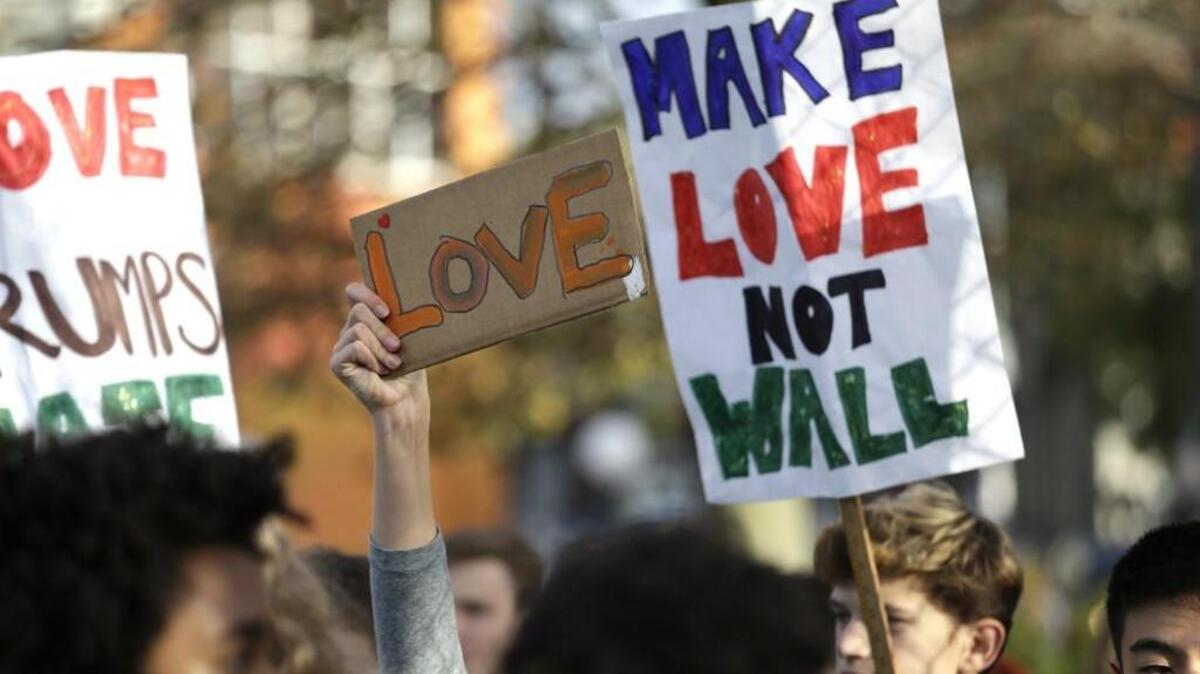 Students hold up signs during a walkout to protest the election of Donald Trump as president, Monday, Nov. 14 in Seattle.