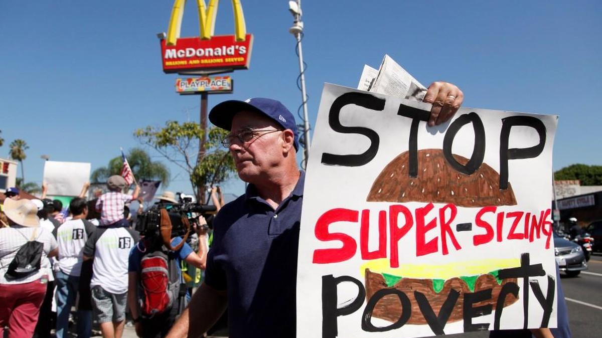 A protester outside a fast food restaurant on Thursday Aug. 29, 2013 in Los Angeles. Fast-food protests were under way Thursday in U.S. cities including New York, Chicago and Detroit, with organizers expecting the biggest national walkouts yet in a demand for higher wages.