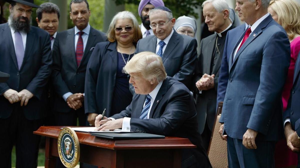 President Donald Trump on May 4 signs an executive order aimed at easing an IRS rule limiting political activity for religious organizations.