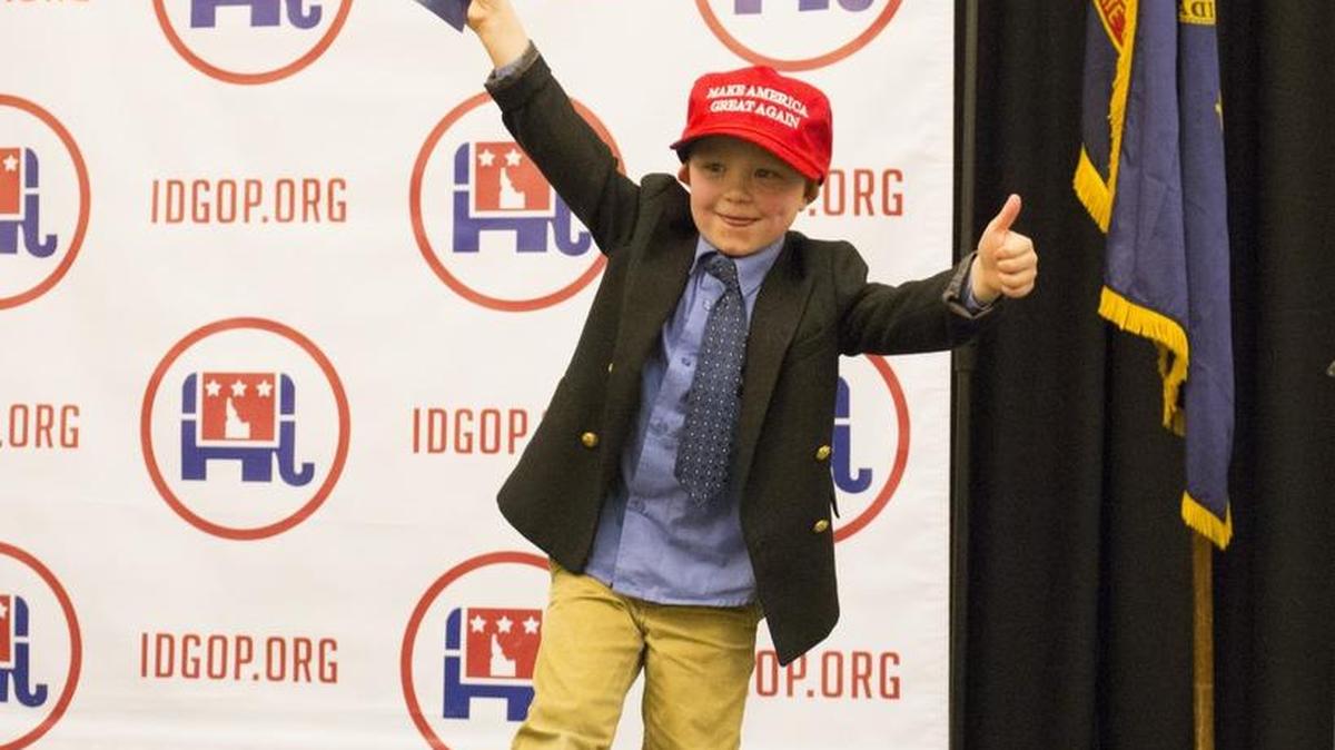Five-year-old Axel Kiska climbs onto the stage with a Republican presidential candidate Donald Trump hat and sign as the crowd waits for election results in Idaho.