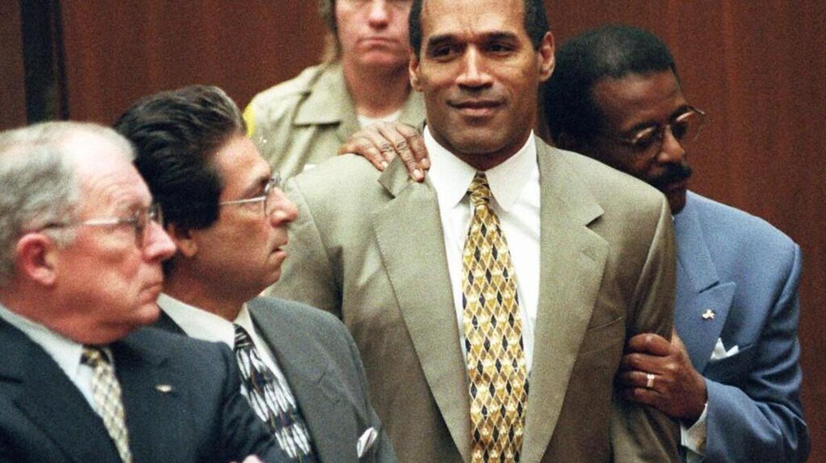 Attorney Johnnie Cochran Jr. holds onto O.J. Simpson as the not guilty verdict is read in a Los Angeles courtroom on Oct. 3, 1995. Left is F. Lee Bailey and second from left is Robert Kardashian.