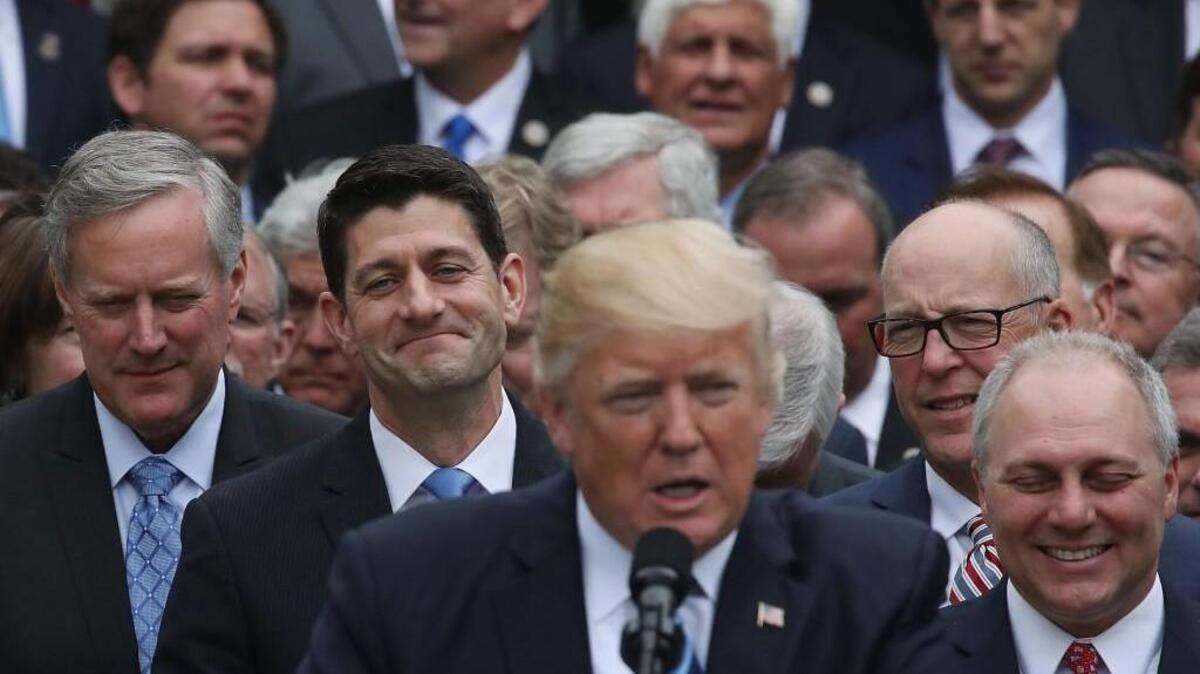 House Speaker Paul Ryan (R-WI) (2nd-L) listens as U.S. President Donald Trump congratulates House Republicans after they passed legislation aimed at repealing and replacing ObamaCare, during an event in the Rose Garden at the White House, on May 4 in Washington, DC.