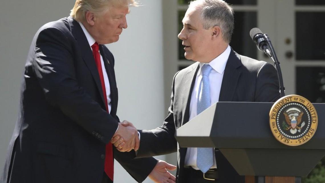 In this June 1, 2017 file photo, President Donald Trump shakes hands with EPA Administrator Scott Pruitt after speaking about the US role in the Paris climate change accord in the Rose Garden of the White House in Washington. Trump's recent decision to pull the United States from the international climate deal reached in Paris was but the latest in a rapid-fire series of moves that would weaken or dismantle federal initiatives to reduce carbon emissions, which scientists say are heating the planet to levels that could have disastrous consequences.
