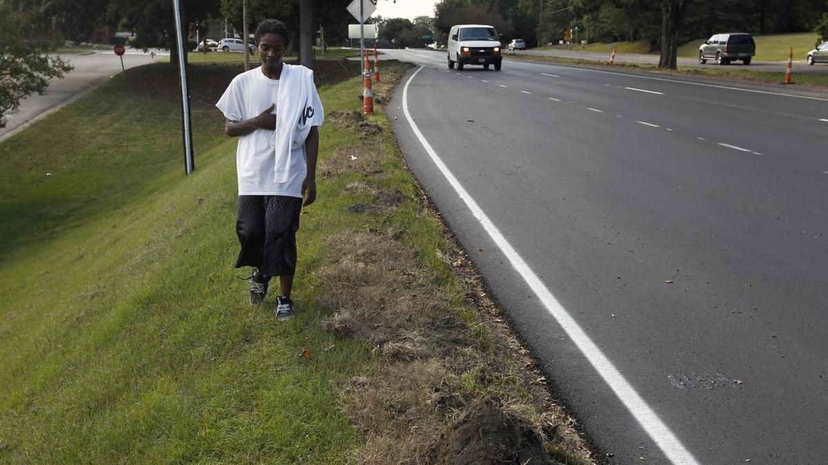 Tyrone Stroble walks close to the road where there is no sidewalk on New Bern Ave. near Clarendon Cresent Rd. in Raleigh.
