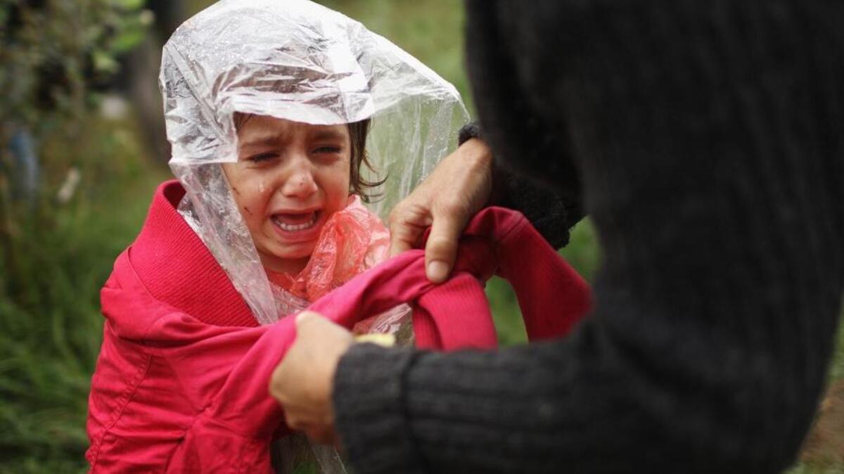 
A young migrant girl cries from the cold and rain as she and her mother make their way through Serbia heading toward a break in the steel and razor fence erected on the border by the Hungarian government.
