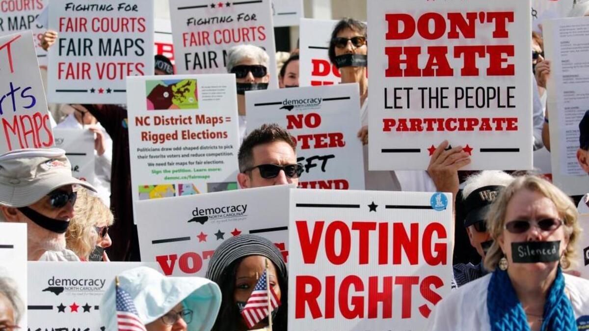 In this Oct. 4, 2017 photo about 100 protesters opposed to Republican-drawn redistricting maps march in silence to the Legislative Building in Raleigh to voice their opposition.