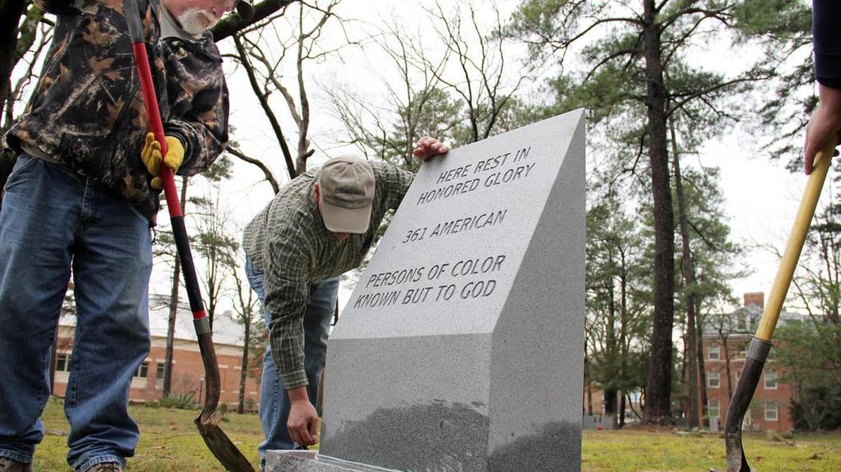 Ronnie Pennell and owner Greg Campbell of Chatham Monument Co. install a marker Thursday, Feb. 4, 2016, to honor 361 people of color who were buried in the Old Chapel Hill cemetery without headstones and in some cases without coffins.