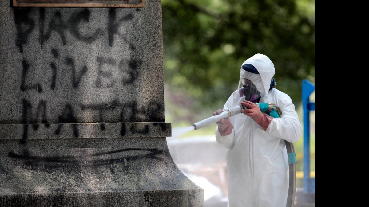 
A worker blasts one face of the sandstone base of the Silent Sam monument on the UNC-CH campus removing black acrylic spray paint graffiti.
