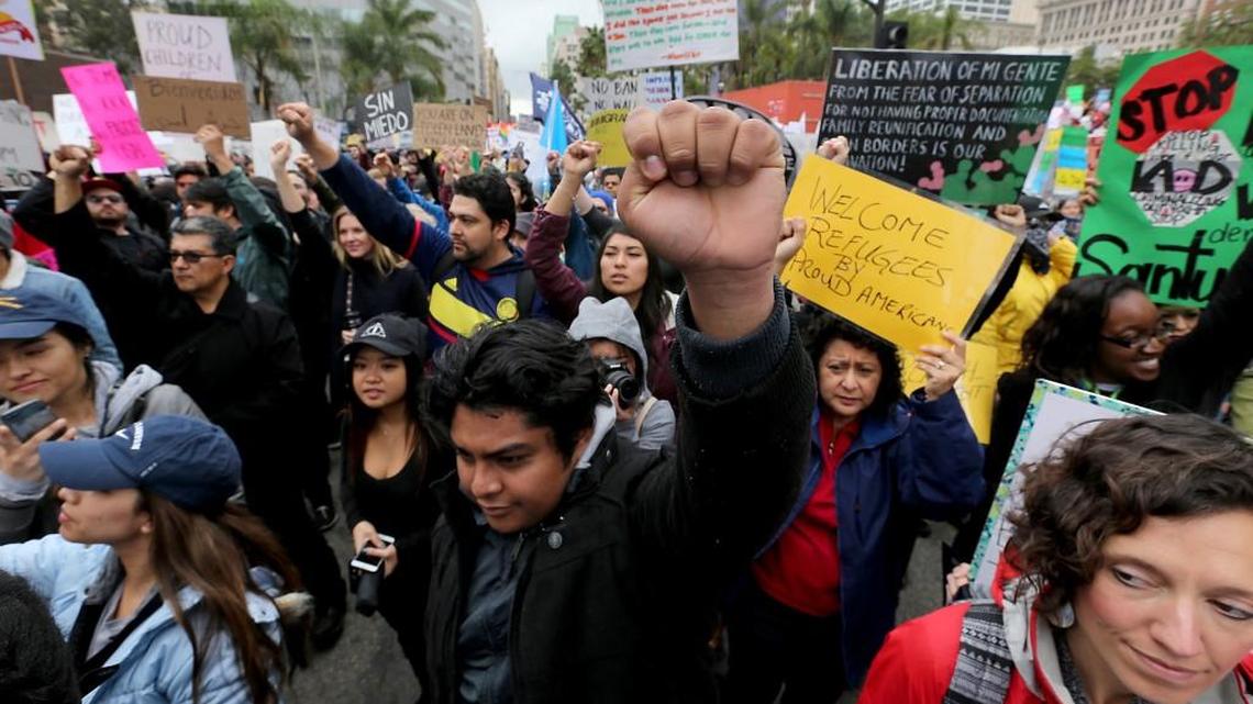 A protester raises a clenched fist, joining hundreds in downtown Los Angeles for a march against President Trump's immigration policies, on February 18, 2017.