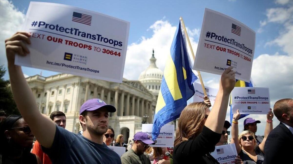 WASHINGTON, DC - JULY 26: Gay rights supporters hold signs during a press conference at the U.S. Capitol condemning the new ban on transgendered servicemembers on July 26, 2017 in Washington, DC. U.S. Rep. Joe Kennedy held a news conference with members of the House leadership and the LGBT Equality Caucus to denounce the decision by U.S. President Donald Trump to ban transgendered servicemembers.