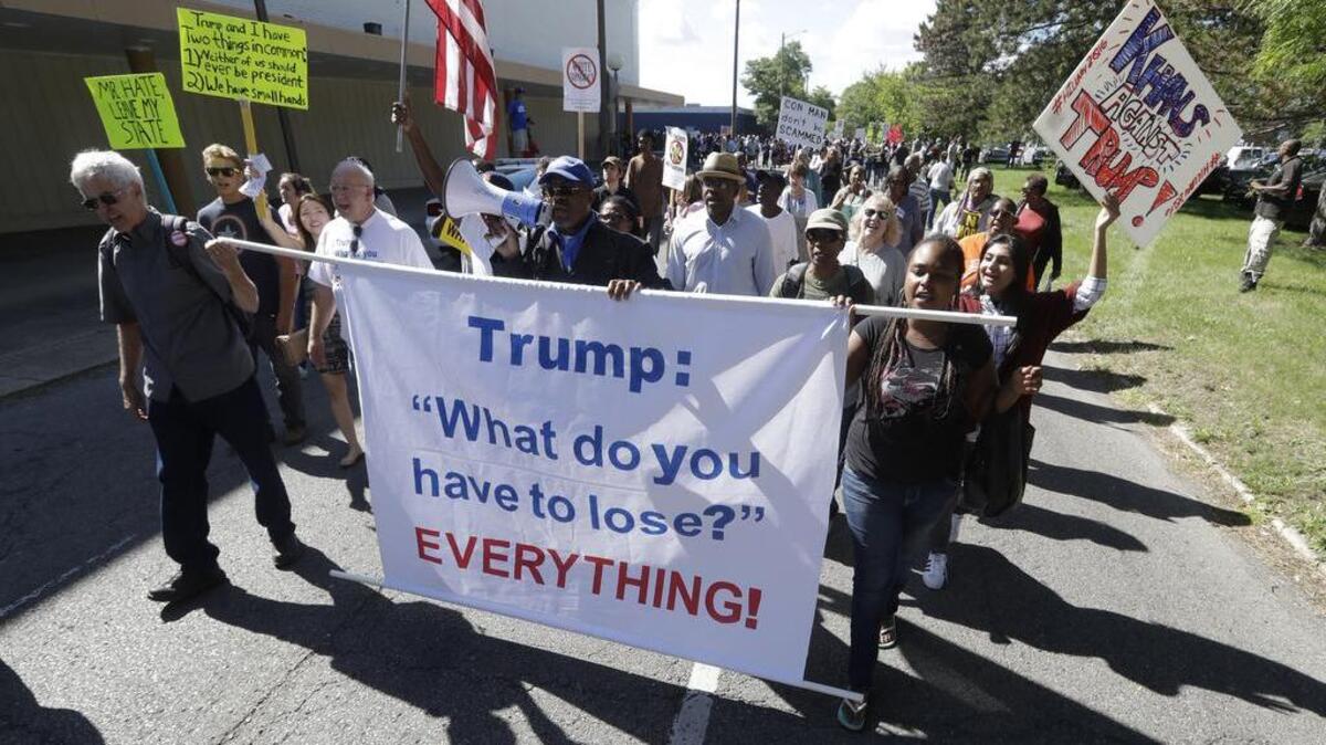 Protesters march outside the Great Faith Ministries International church in Detroit, where Donald Trump visited with the church members.