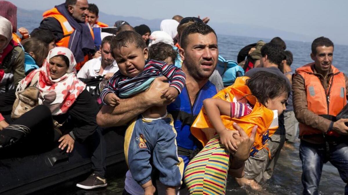 Syrian refugees arrive aboard a dinghy after crossing from Turkey to the island of Lesbos, Greece.