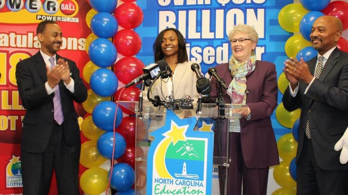 In this undated photo provided by the North Carolina Education Lottery, shows Powerball jackpot winner Marie Holmes, second from left, after she received a check from North Carolina Education Lottery executive director Alice Garland, second from right, in Raleigh, N.C. To the left is financial adviser Dexter Perry and attorney Charles Francis, right. Holmes, a single mother of four, came forward Monday, Feb. 23, 2015, as one of three winners in a huge Powerball jackpot drawn earlier this month.