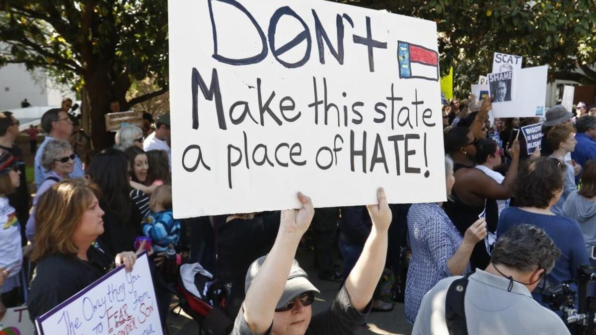 Nicole Root of Cary, NC stood silently with her protest sign facing the Governor's Mansion as others sang and chanted on North Blount Street as Triangle Families Against HB2 loudly noted their distaste for HB2, the Republican-led Legislature and NC Governor Pat McCrory on April 2.