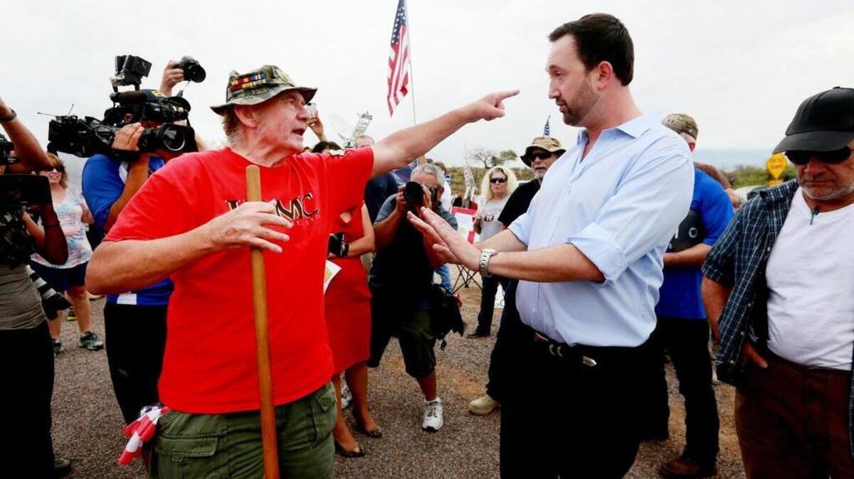 Tea Party member Adam Kwasman, right, running for Congress, has a heated discussion at an anti-immigration protest in July 2014 in Oracle, Ariz. The N&O’s May 24 Community Voices forum will focus on talking across the political divide.