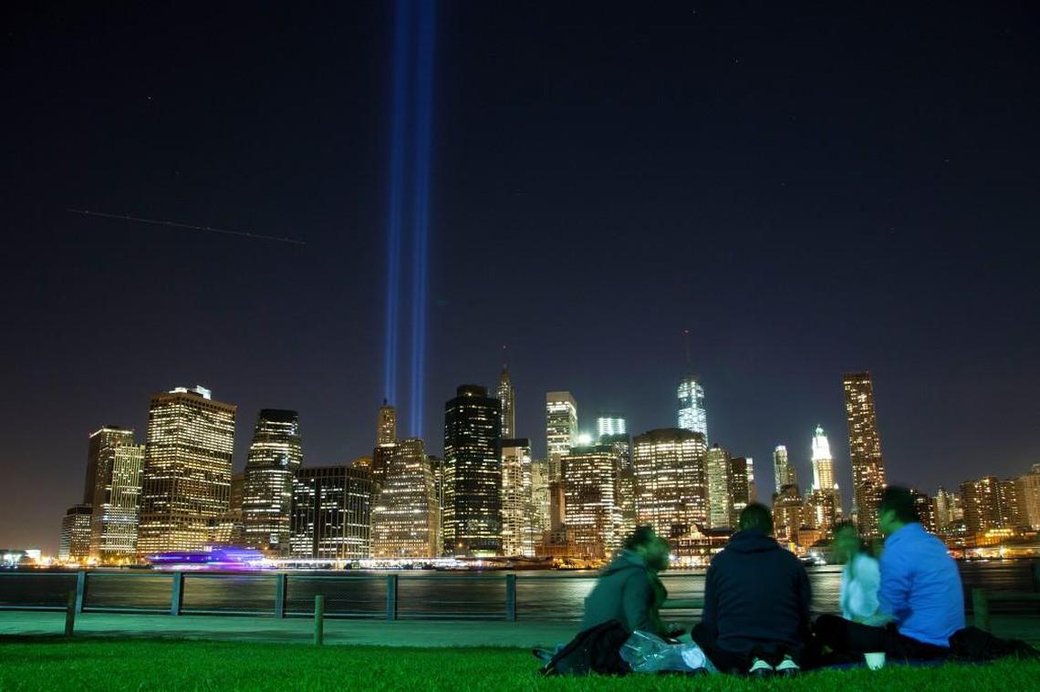 People in Brooklyn Bridge Park gather to watch a test of the Tribute in Light rising from the lower Manhattan skyline in New York in this Sept. 7, 2013 photo. The Tribute, which commemorates the fallen twin towers, will be on display, Wednesday, Sept. 11, the 12th anniversary of the terrorist attacks.
