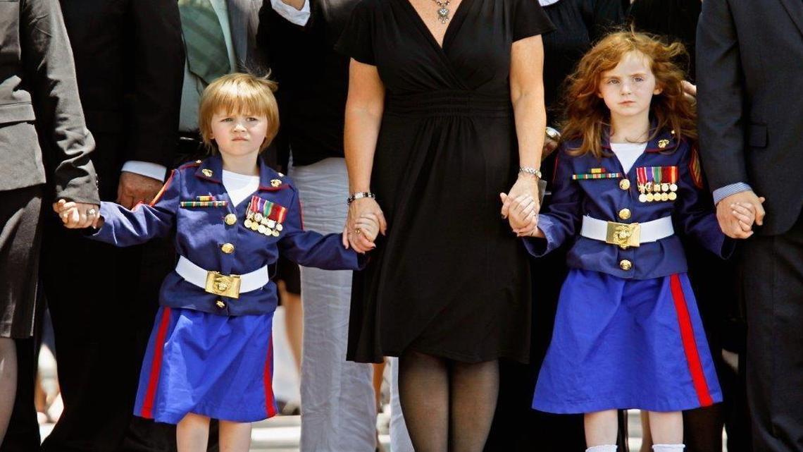 Sisters Eden Balduf (L), 3, and Stephanie Balduf, 5, wear Marine Corps-inspired uniforms while walking with their family during the burial ceremony for their father, U.S. Marine Corps Sergeant Kevin Balduf, at Arlington National Cemetery June 15, 2011 in Arlington, Virginia. Assigned to 8th Communications Battalion, II Marine Expeditionary Force, Camp Lejeune, Balduf was killed May 12, 2011 in Helmand province, Afghanistan, when he was shot and killed by a rogue Afghan policeman.