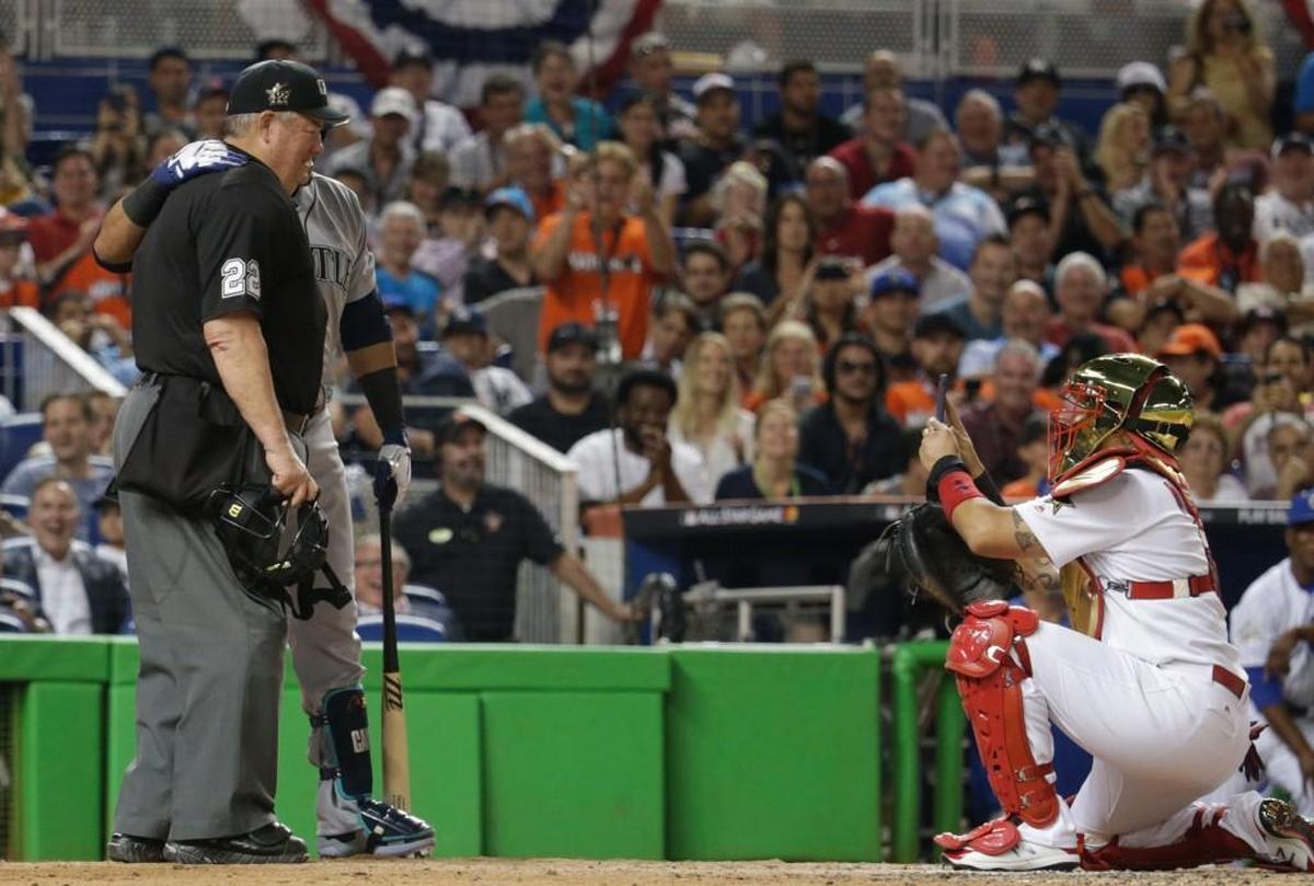 Cleveland Indians outfielder Michael Brantley of the National League poses for a photo with home plate umpire Joe West, as National League catcher Yadier Molina, right, takes a photo, during the MLB baseball All-Star Game, Tuesday, July 11, 2017, in Miami. (AP Photo/Alan Diaz)