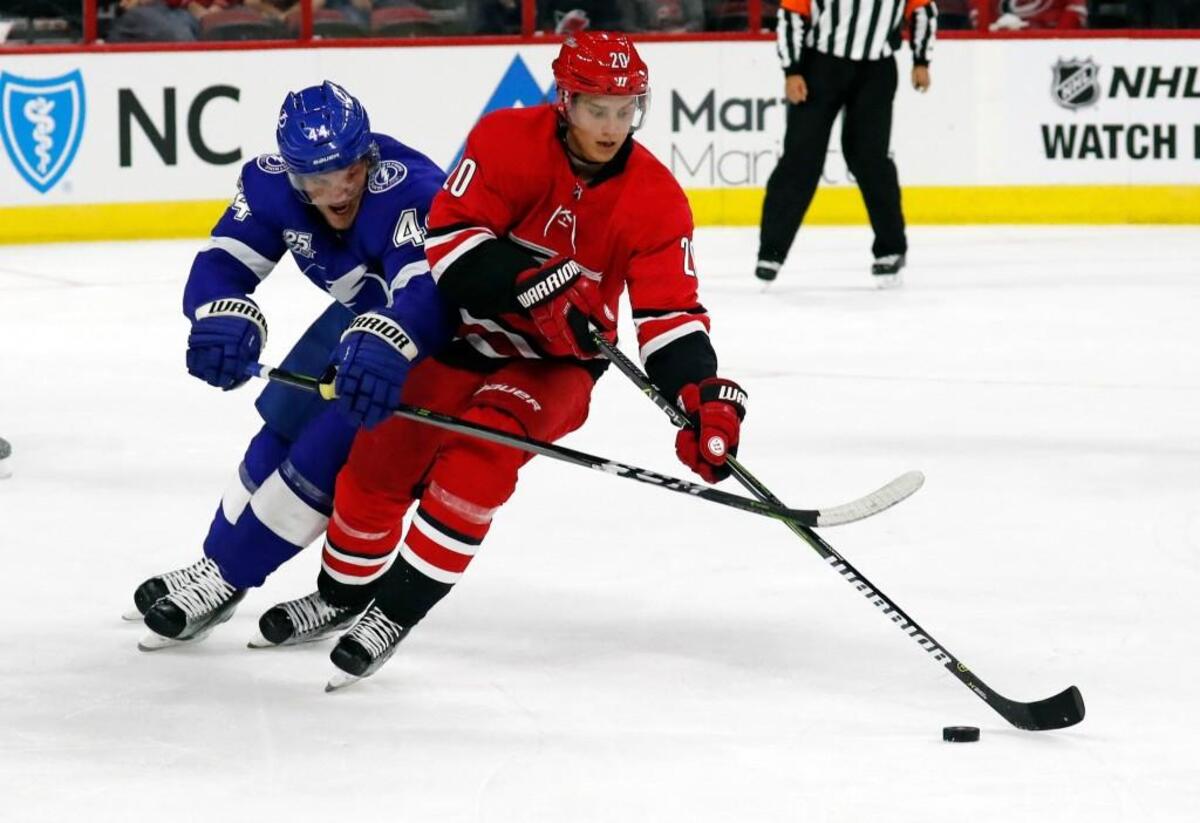 The Canes' Sebastian Aho (20) moves against Tampa Bay's Tye McGinn (44).