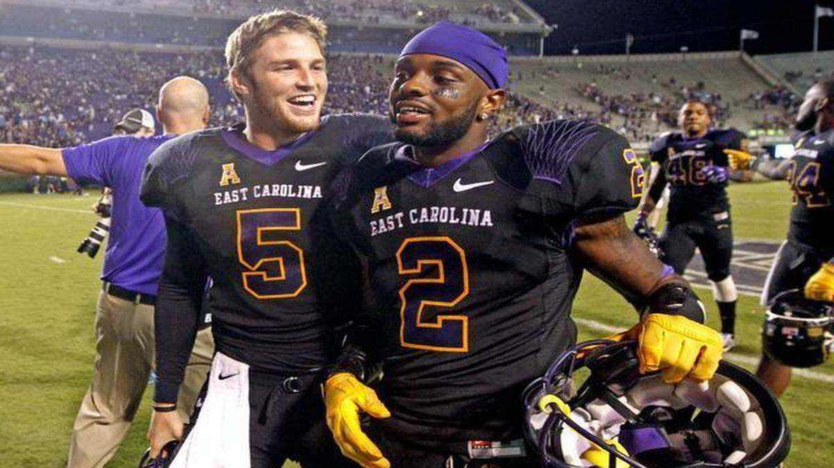 
East Carolina quarterback Shane Carden (5) and wide receiver Justin Hardy (2) walk off the field after East Carolina's 70-41 victory over North Carolina at Dowdy-Ficklen Stadium in Greenville, N.C., Saturday, Sept. 20, 2014.
