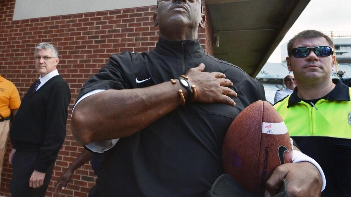 ECU head coach Ruffin McNeill holds the game ball and salutes the Pirate faithful as he leaves the field after the Pirates beat the UNC Tar Heels 55-31 at Kenan Stadium in Chapel Hill, NC Saturday Sept.28, 2013.