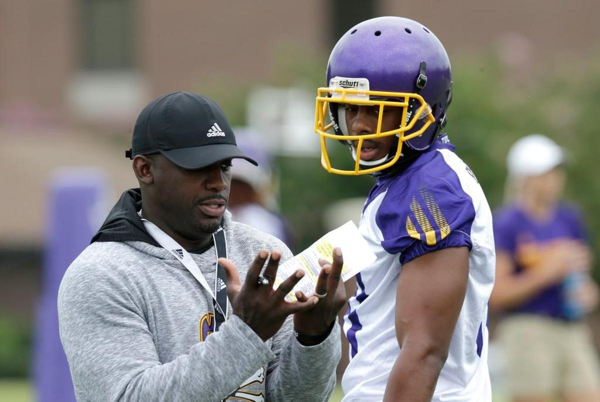 East Carolina coach Scottie Montgomery, left, speaks with wide receiver Jimmy Williams during an NCAA college football practice in Greenville, N.C., Friday, Aug. 4, 2017.