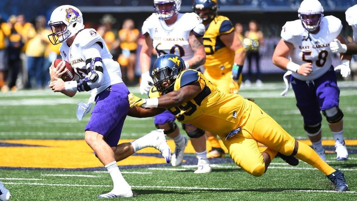 Thomas Sirk. left, of the East Carolina Pirates avoids a tackle by Xavier Pegues of West Virginia Mountaineers at Mountaineer Field on September 9, 2017 in Morgantown, West Virginia. (Photo by Joe Sargent/Getty Images)