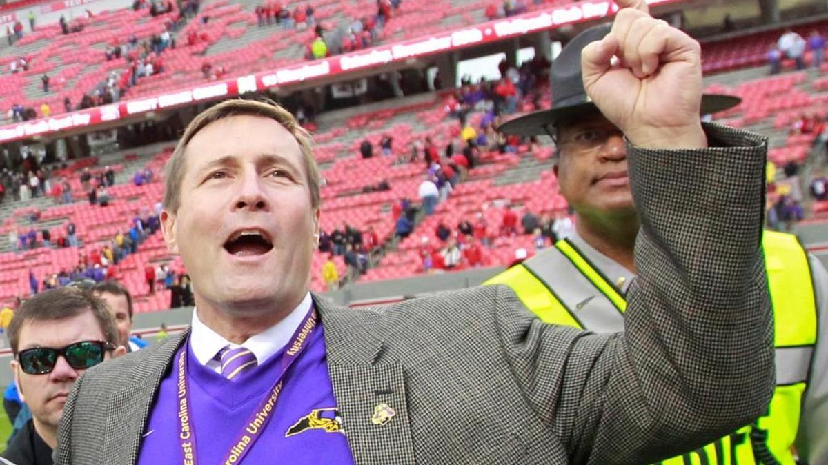 East Carolina Director of Athletics Jeff Compher celebrates after the Pirates’ 42-28 victory over N.C. State at Carter-Finley Stadium in Raleigh, N.C., Saturday, Nov. 23, 2013.