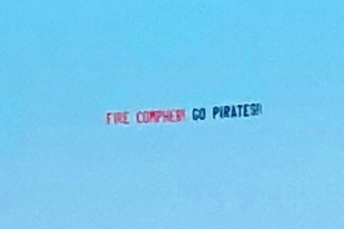 A photo of a “Fire Compher! Go Pirates!” banner that East Carolina University alum John Bream had fly over Greenville, N.C. on a football gameday in a campaign against ECU athletic director Jeff Compher.