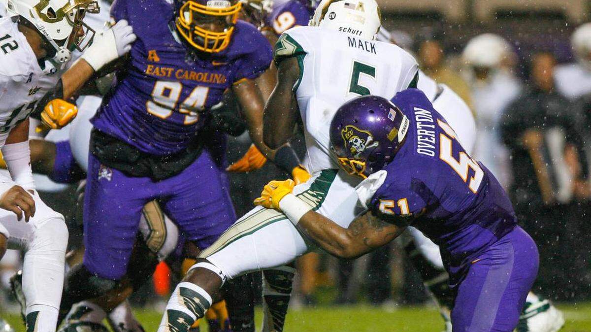 South Florida's Marlon Mack is tackled by East Carolina's Montese Overton during the first half in Greenville.