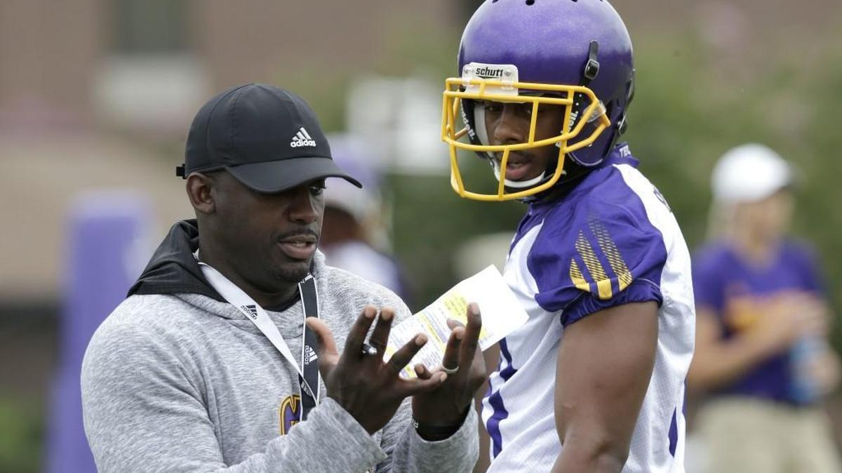 ECU football coach Scottie Montgomery, left, speaks with wide receiver Jimmy Williams during practice on Aug. 4.