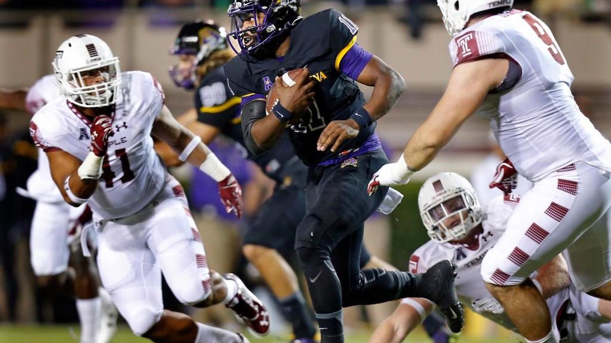East Carolina’s James Summers, center, runs against Temple’s Jarred Alwan, left, and Matt Ioannidis, right, during the first half of their game played in Greenville on Thursday night. The game was not over in time for this edition. Check nando.com/sports for more on this game.