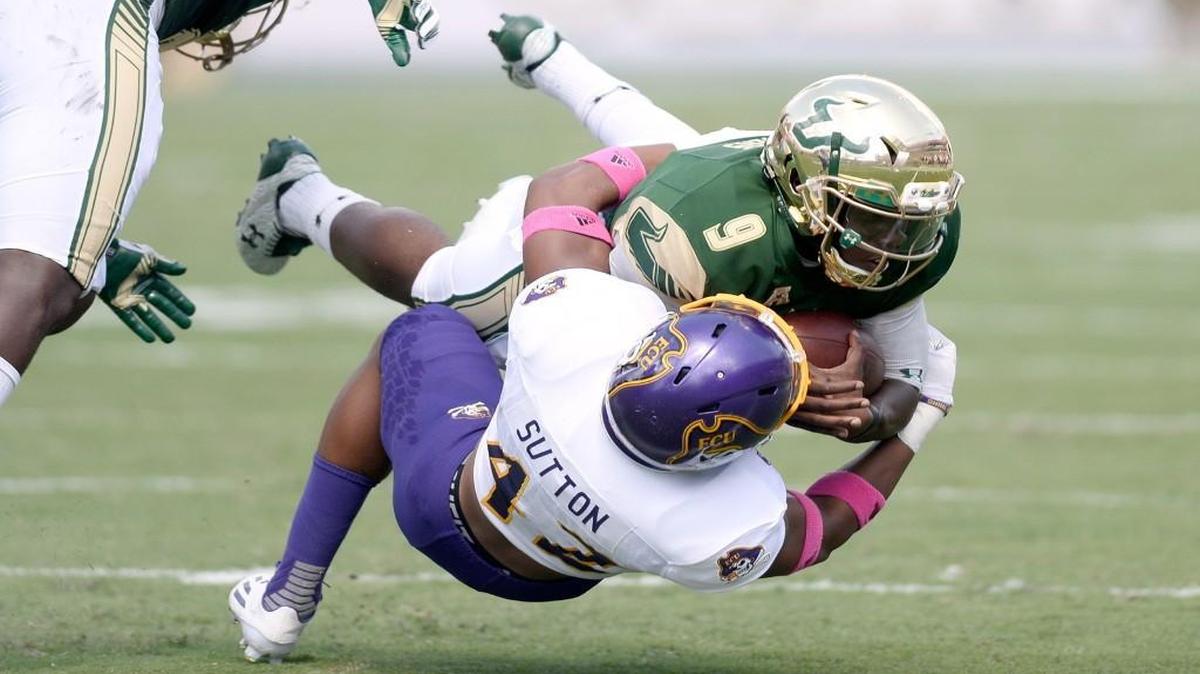 East Carolina defensive back Devon Sutton (42) tackles South Florida quarterback Quinton Flowers during the 1st quarter at Raymond James Stadium.