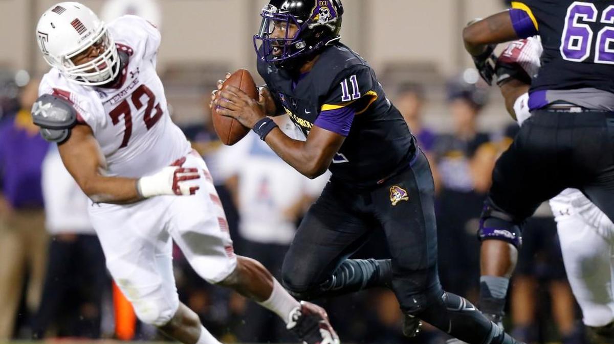 ECU's James Summers (11) rolls out against Temple’s Hershey Walton (72) during the Pirates’ 24-14 loss on Oct. 22. ECU faces Connecticut Friday night.