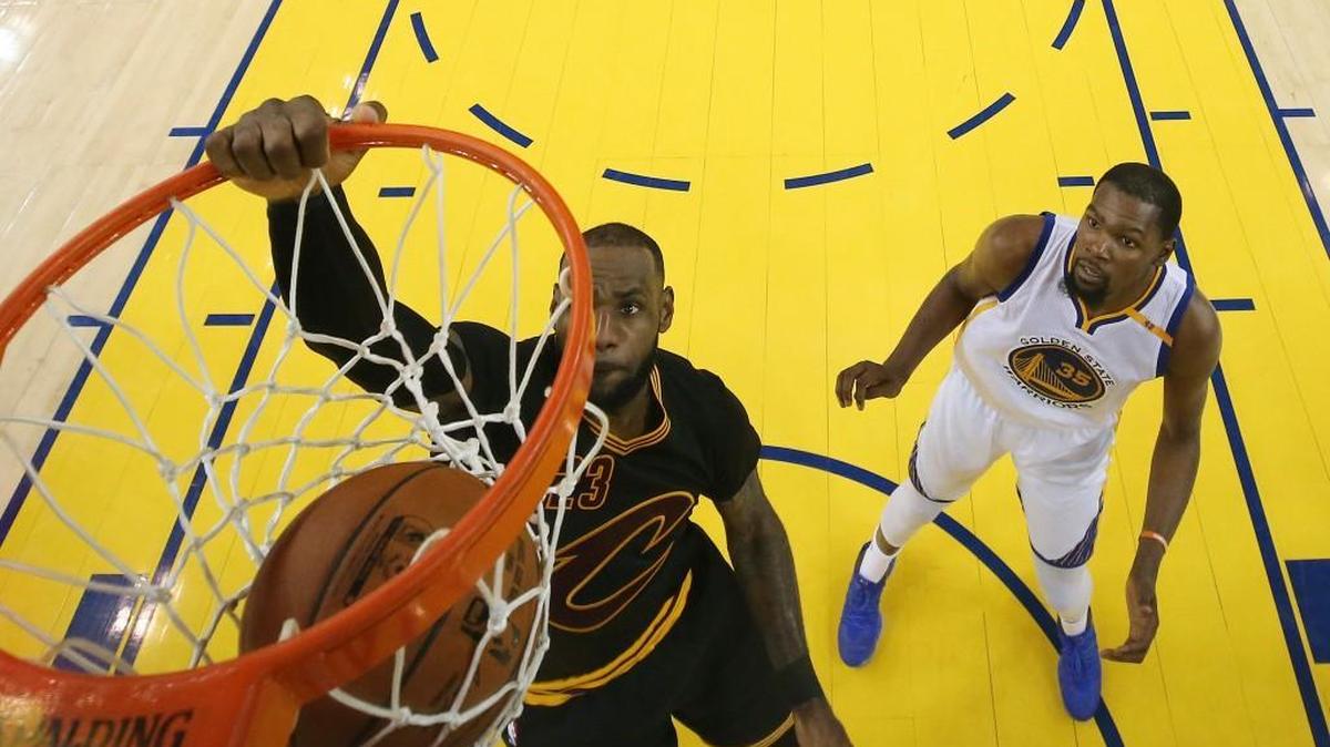 Cleveland Cavaliers forward LeBron James, left, dunks in front of Golden State Warriors forward Kevin Durant (35) during the second half of Game 5 of the NBA Finals in Oakland, Calif., on June 12, 2017. The Warriors won 129-120 to win the NBA championship. (Ezra Shaw/Pool Photo via AP)