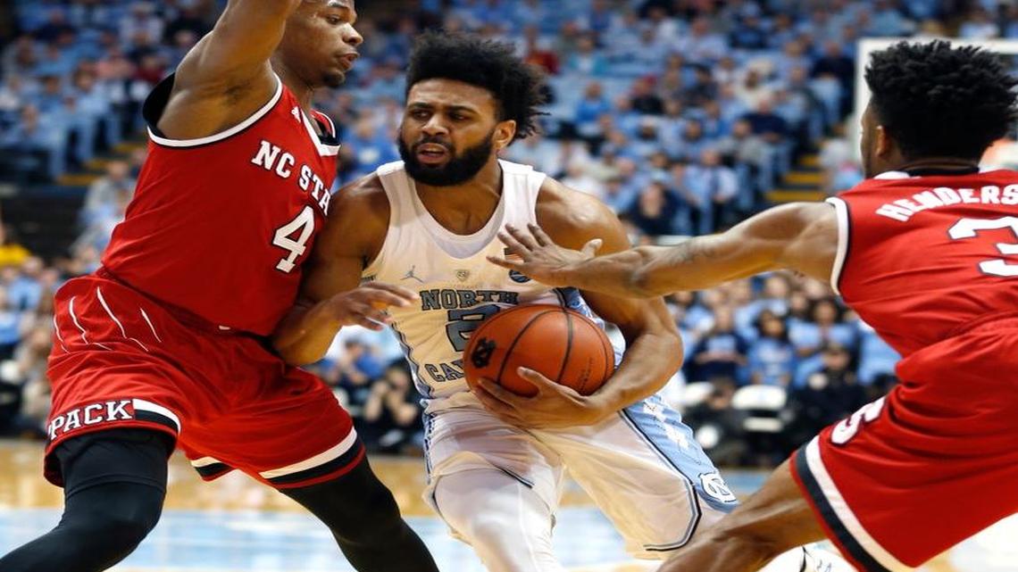 North Carolina's Joel Berry II (2) drives around N.C. State's Dennis Smith Jr. (4), left, and Terry Henderson (3) during the first half of the Wolfpack's game against UNC at the Smith Center in Chapel Hill, N.C., Sunday, Jan 8, 2017.