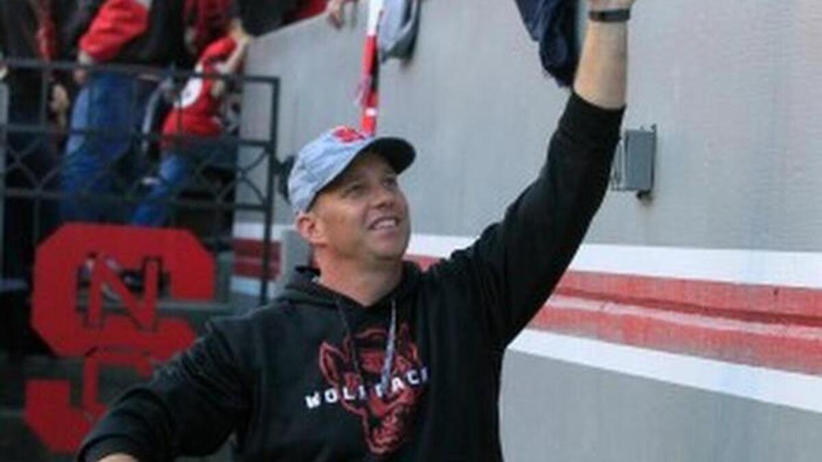 N.C. State head coach Dave Doeren high-fives fans after N.C. State's 42-29 victory over Syracuse at Carter-Finley Stadium in Raleigh on Saturday.