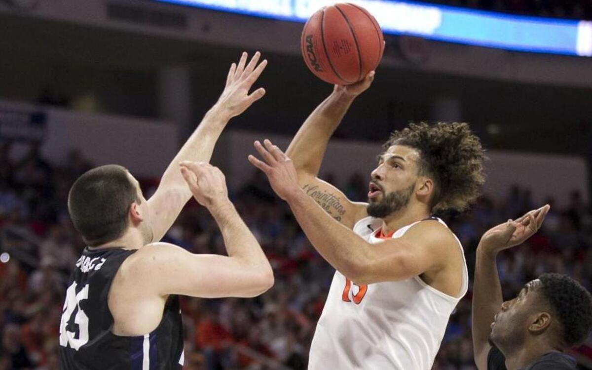 Virginia’s Anthony Gill puts up a shot over Butler’s Steven Bennett (25) during the first half in the second round of the NCAA tournament at the PNC Arena.