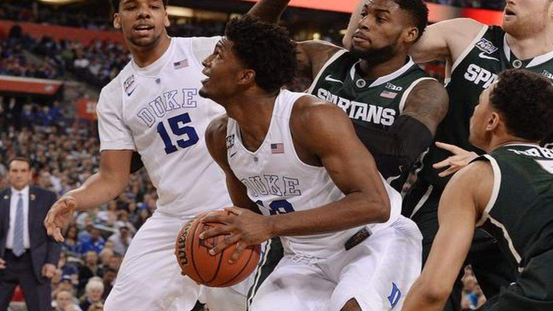 
Duke forward Justise Winslow (12) and teammate center Jahlil Okafor (15) draw a crowd of Michigan State defenders under the basket in the second half of play. Duke will advance to the NCAA national championship game after defeating Michigan State 81-61 at Lucas Oil Stadium in Indianapolis, Indiana Saturday, April 4, 2015.
