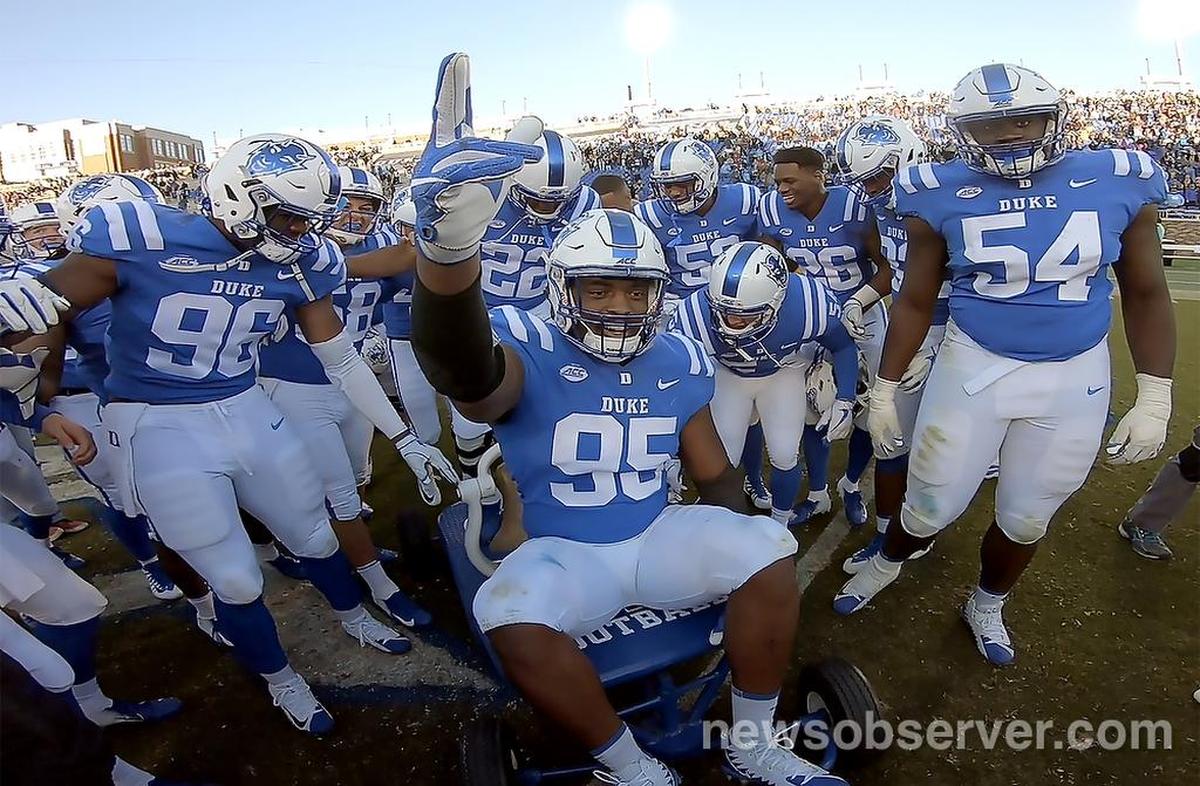 Duke defensive tackle Trevon McSwain (95) leads the celebration on the Victory Bell with teammate and signals “three peat” as Duke defeated UNC 42-35 at Wallace Wade Stadium In Durham, N.C., Saturday, Nov. 10, 2018