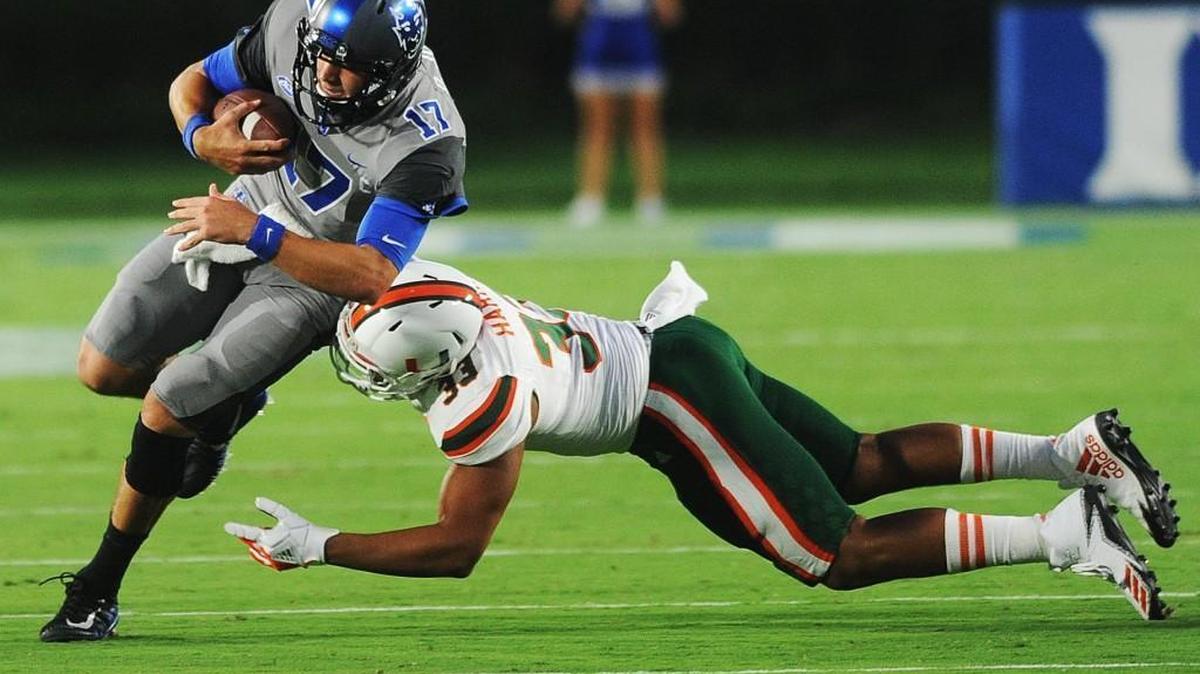 Duke quarterback Daniel Jones (17) runs by Miami's Trent Harris (33), Friday, September 29, 2017, in Wallace Wade Stadium.